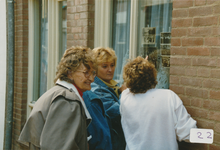 863101 Afbeelding van enkele dames in de Willemstraat in Wijk C te Utrecht, die foto's becommentarieren, die opgehangen ...